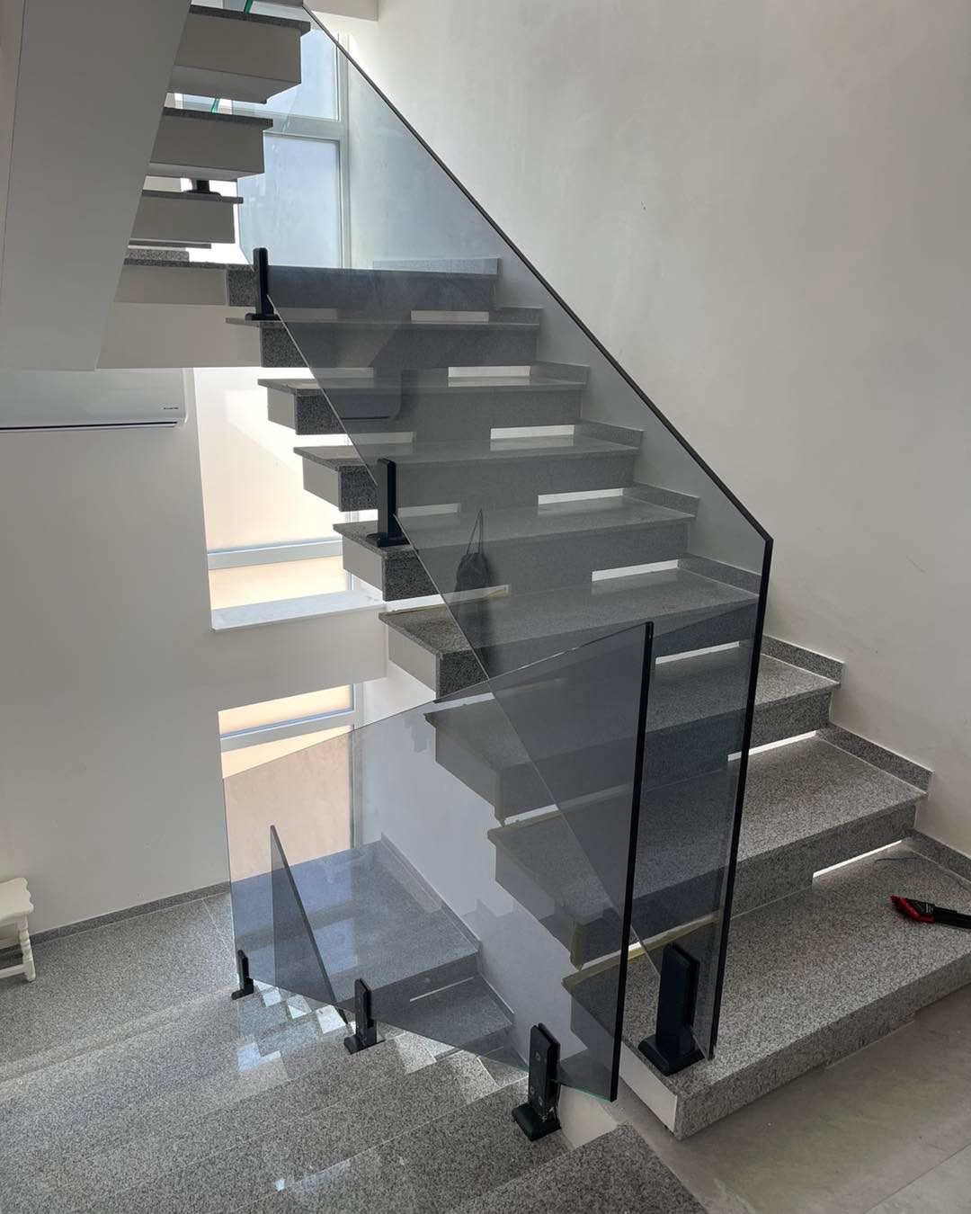 Frameless glass balustrade on a floating granite staircase